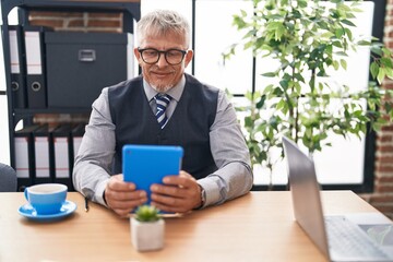 Wall Mural - Middle age grey-haired man business worker using touchpad at office