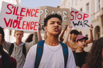 Wall Mural - Teenage boy marching against war with a group of protestors