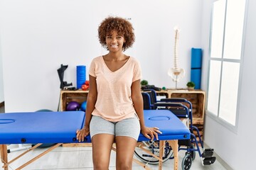 Poster - Young african american woman smiling confident sitting on massage board at clinic