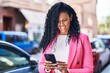 © Krakenimages.com - African american woman executive using smartphone at street