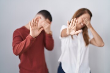 Sticker - Mother and son standing together over isolated background covering eyes with hands and doing stop gesture with sad and fear expression. embarrassed and negative concept.