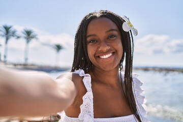 Sticker - Young african american girl smiling happy make selfie by the camera at the beach.