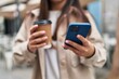 © Krakenimages.com - Young hispanic woman using smartphone drinking coffee at street