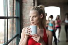 Portrait Of Young Woman In A Gym While Drinking From A Cup