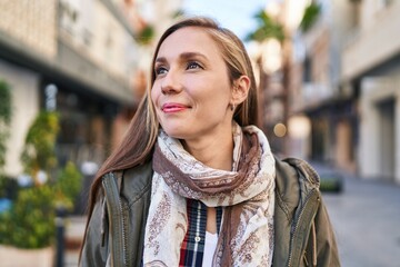 Young blonde woman smiling confident looking to the side at street