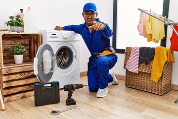 Canvas Print - Young indian technician working on washing machine pointing displeased and frustrated to the camera, angry and furious with you