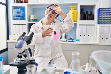 Sticker - Hispanic girl with down syndrome working at scientist laboratory touching forehead for illness and fever, flu and cold, virus sick