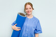 © Asier - Young caucasian physiotherapist holding a mat isolated on blue background happy, smiling and cheerful.
