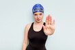 © Asier - Young caucasian swimmer woman isolated on blue background standing with outstretched hand showing stop sign, preventing you.