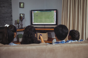 Canvas Print - Diverse children watching tv with football match on screen