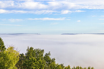 Wall Mural - Valley with fog and mountains protruding from the fog