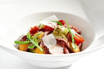 Canvas Print - Roast beef and grilled vegetables salad isolated on white background. Steak salad with pastrami, eggplant, tomato, remoulade sauce with parmesan flakes. Gourmet dish  with grilled meat and vegetables.