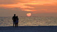 Beach Lovers Watch The Sunset Over Sanibel Island From Fort Myers Beach, Florida, USA.