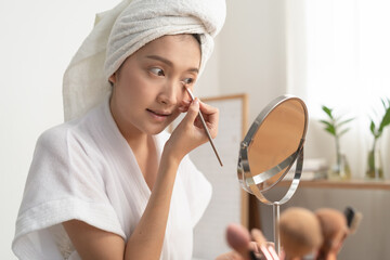 Wall Mural - Asian woman drawing eyebrow to her face.