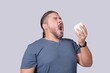 © Mdv Edwards - A man in his 30s is about to sneeze into a tissue paper. Triggered by an allergy or a cold.