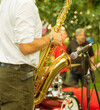 Saxophonist in the process of playing the saxophone during a performance at a street festival
