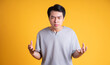 © 1112000 - Asian young man posing on a yellow background