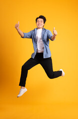 Wall Mural - full body image of asian man posing on yellow background