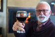 © Solid photos - Senior man drinking wine while sitting by the fireplace