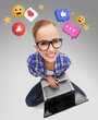 © Syda Productions - social media, technology and blogging concept - smiling woman or student girl in glasses with laptop computer sitting on floor with internet icons over grey background