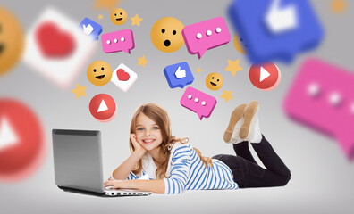 Wall Mural - social media, technology and blogging concept - smiling little student girl with laptop computer lying on floor with internet icons over grey background