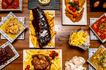 Wall Mural - Recipes of Spanish dishes and tapas with croquettes of various flavors, charcoal chicken, cachopo, garlic chicken, wine sausages and barbecued ribs