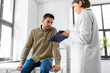 © Syda Productions - medicine, healthcare and people concept - female doctor with clipboard and male patient having health problem at hospital