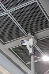 A video surveillance camera under a metal ceiling