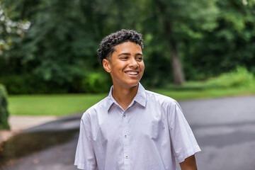 A close up image of a handsome teenage guy laughing and looking away