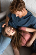 © LIGHTFIELD STUDIOS - top view of redhead and smiling young man stroking hair of cheerful girlfriend in living room.