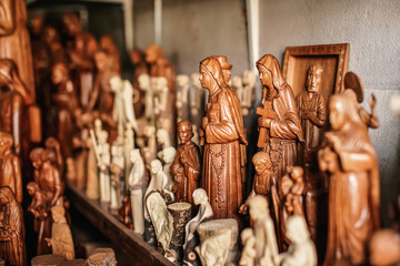 Various handmade religious souvenirs from carved wood on display at African market