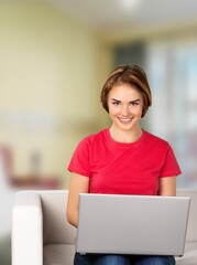 Young woman using laptop computer at home. Female working online.