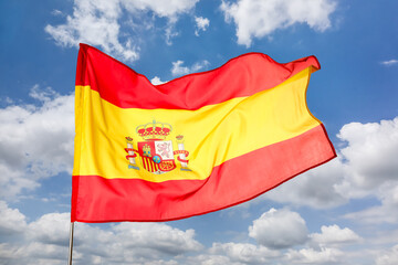 Waving flag of Spain against blue sky