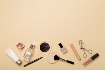 Different makeup products on color background, top view