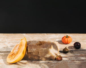 Wall Mural - Retro style composition made of melon fruit, figs, pumpkin and rock on old wooden table. Product podium, suitable for product display. Dark background.