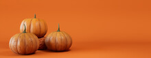 Seasonal Background Banner With Copy-space. Trio Of Pumpkins On Orange Color. Fall Concept.
