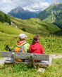 © ARochau - Zwei Teenager sitzen auf einer Bank und genießen den herrlichen Ausblick ins Gebirge