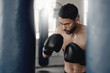 Boxing man, punching bag and strong power, focus mma and fighter training challenge in gym club, exercise and combat sports. Fitness champion, healthy warrior athlete and pro boxer gloves hit impact
