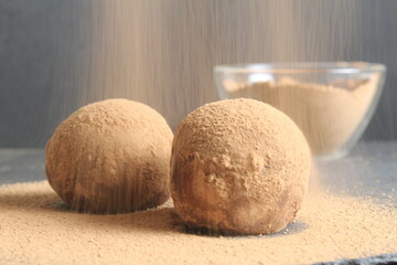 Canvas Print - chocolate cake dessert in the shape of a ball of a circle sprinkled with cocoa powder. homemade dessert day of chocolate sweet tooth. a day without diet