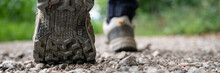 Closeup Wide View Image Of Male Feet In Hiking Shoes Walking On A Gravel Path