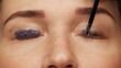 Woman face on modern eyelash lamination procedure in a professional beauty salon. Master applies special glue before the eyelash curling procedure, close up. Beauty salon..
