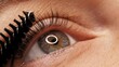 © Valua Vitaly - Applying black mascara to the eyelashes with a makeup brush. Applying makeup in a beauty salon. Close-up of a woman's eye. Lengthening of the eyelashes after lamination.