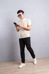 Sticker - Full length image of young Asian man using smarphone