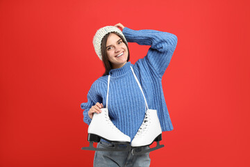 Canvas Print - Happy woman with ice skates on red background