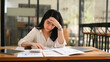 © Prathankarnpap - Stressed business woman suffering from migraine headache, considering financial problem solution