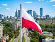 Flaga polski na tle drapaczy chmur w centrum Warszawy na tle niebieskiego nieba, widok z lotu ptaka