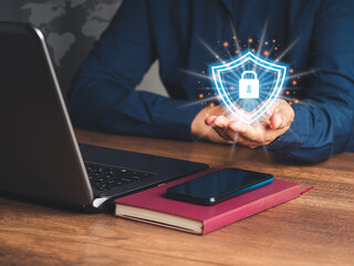 Wall Mural - Businessman holding shield protect icon while sitting at the table