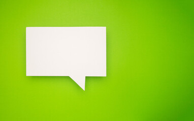 A blank white speech bubble over a light green background