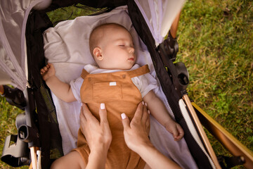 Poster - High angle first person view portrait of mother hands touch sleeping toddler pastime weekend walk outdoors