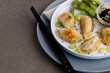 Close up of asian dumplings, soy sauce and chopsticks on grey background